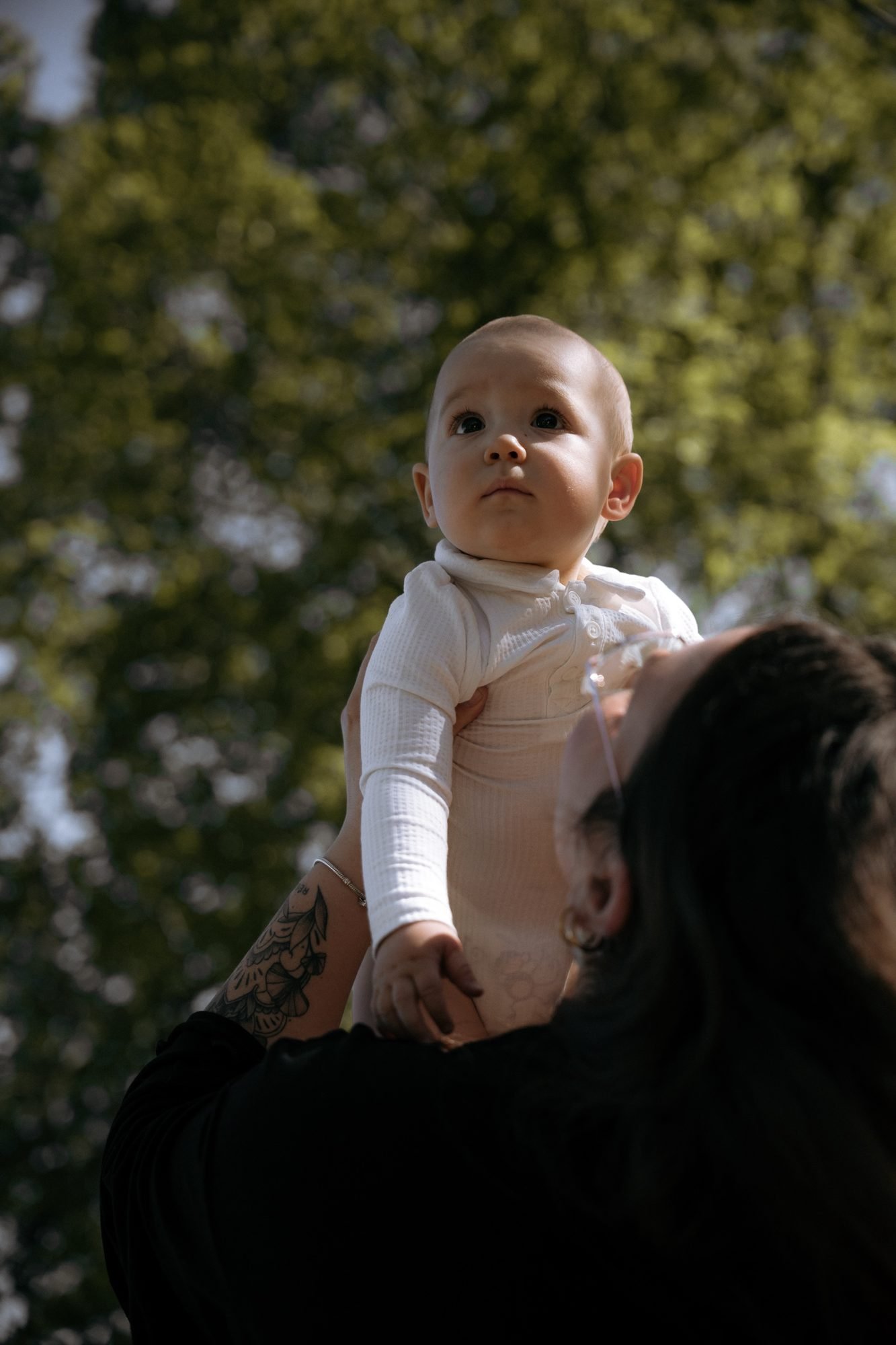 Bébé joue avec les mains de sa maman, décor de pierre
