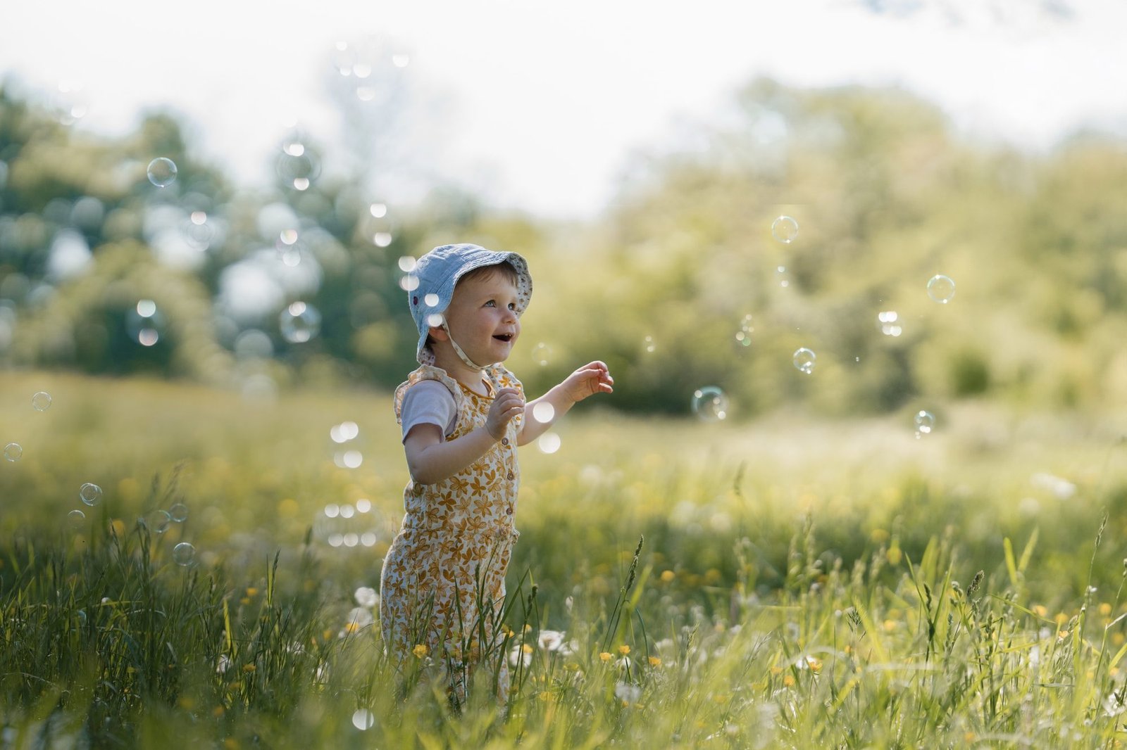 Un bébé souriant regarde dehors, porté par sa maman