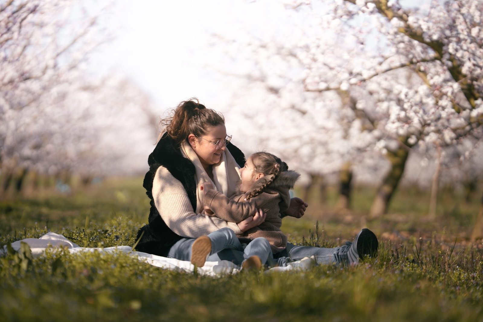 Bébé blotti dans les bras de sa maman, lumière douce à la fenêtre