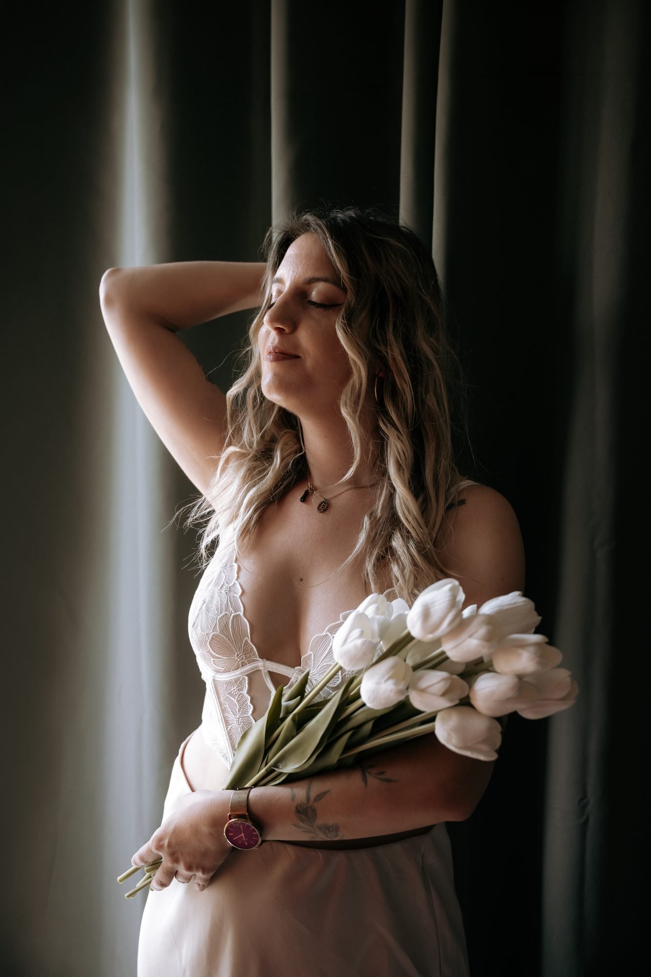 Portrait d'une femme tenant un bouquet de tulipes blanches, lumière tamisée