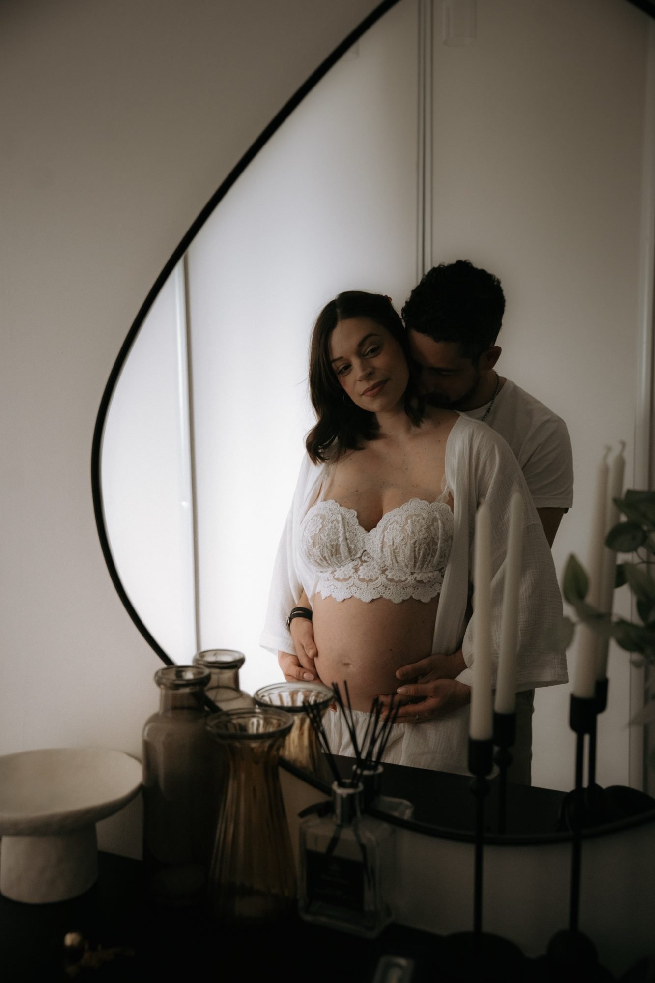 Femme enceinte appuyée contre un plan de travail, tenue blanche