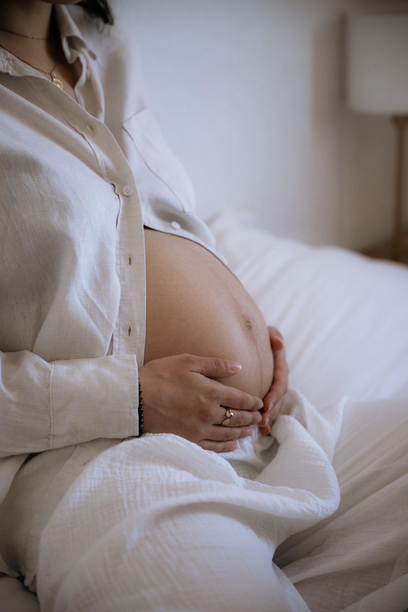 Femme enceinte souriante entourée de fleurs mauves