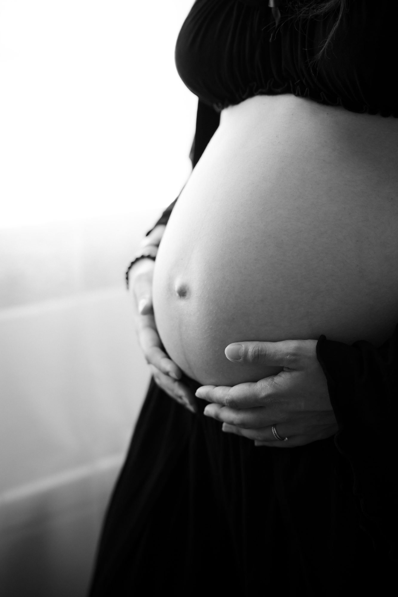 Portrait de femme enceinte appuyée contre un arbre