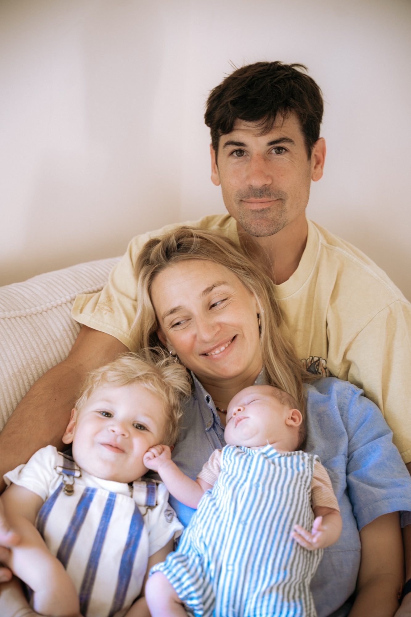 Parents souriants avec leur petit garçon et leur nouveau-né, câlin en famille