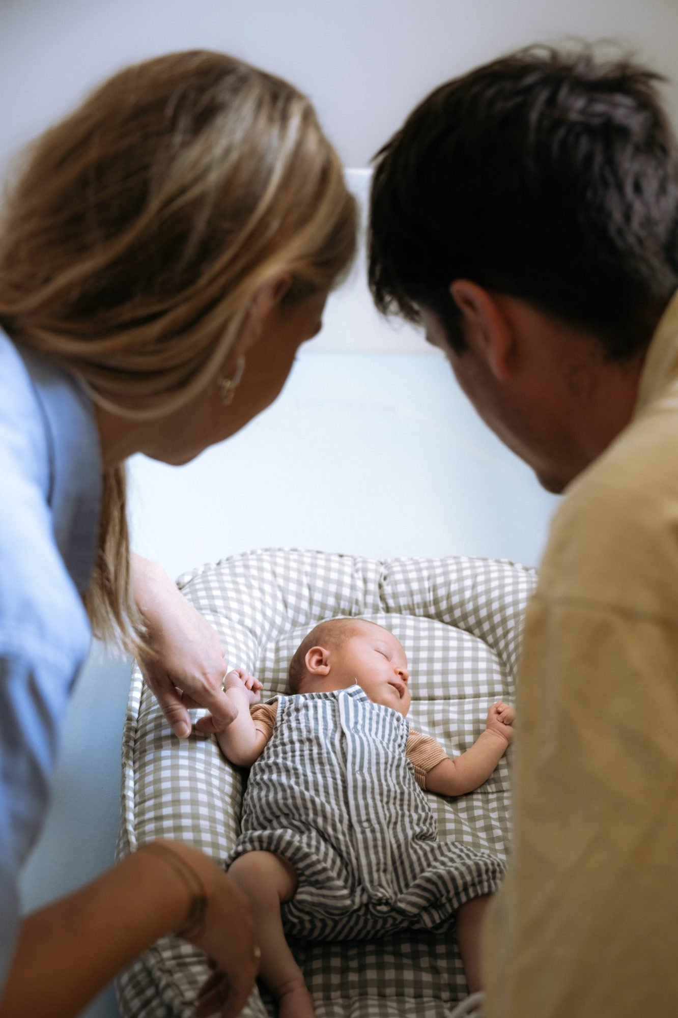 Parents penchés au-dessus de leur nouveau-né endormi