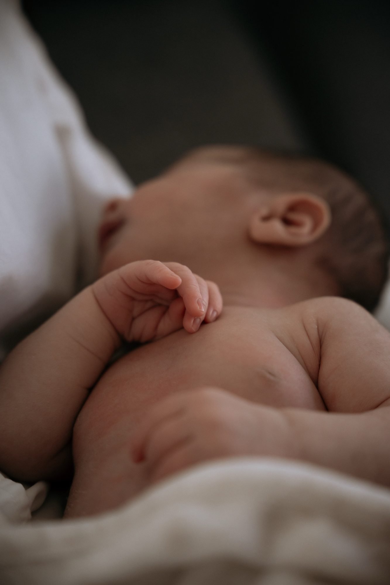 Gros plan sur les mains jointes d'un nouveau-né endormi