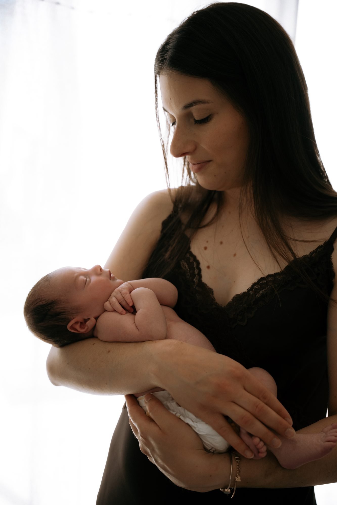 Mère assise dans un hamac tissé, tenant son bébé, chambre d'enfant