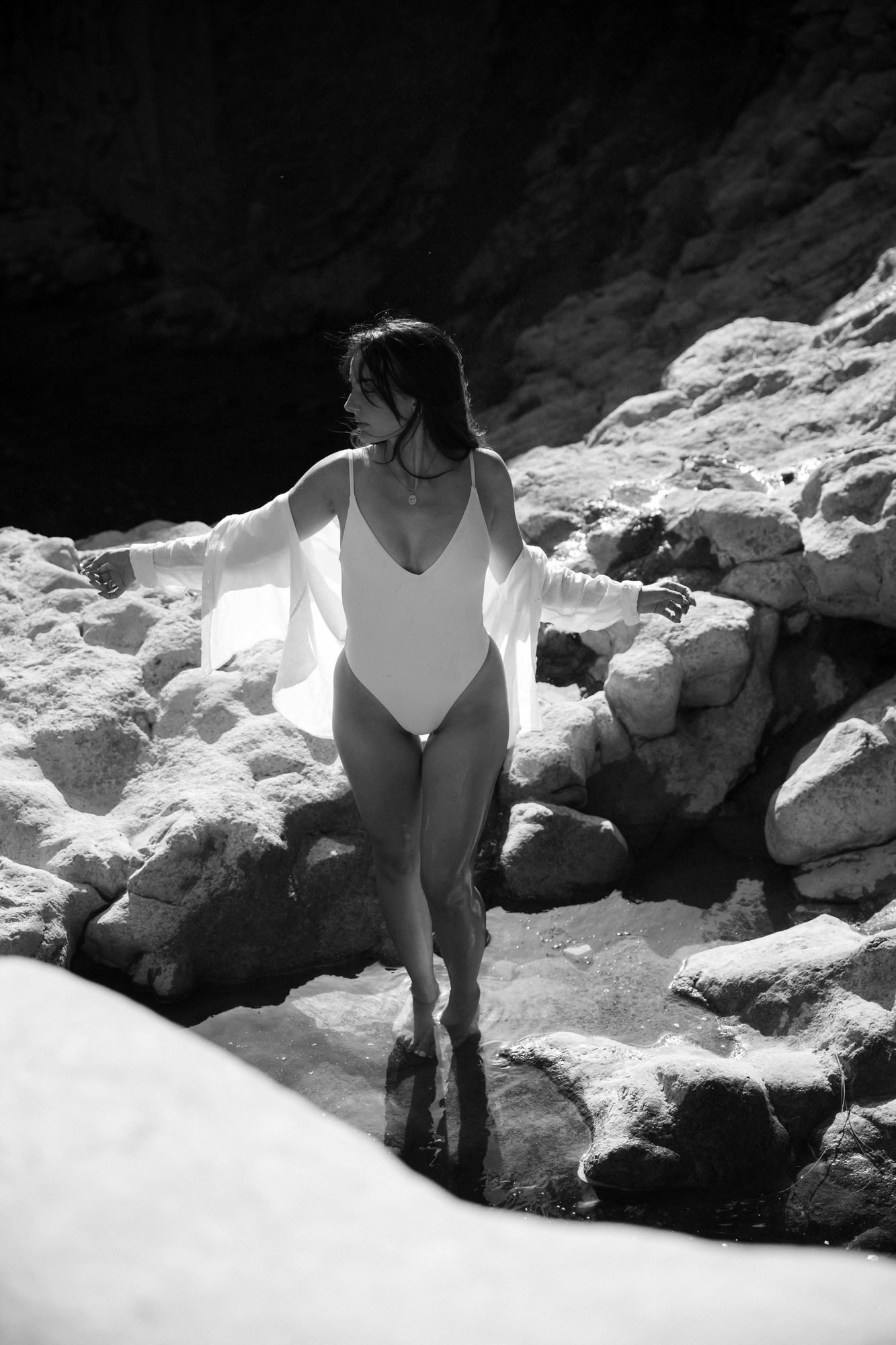 Bras déployés dans la lumière, portrait en noir et blanc