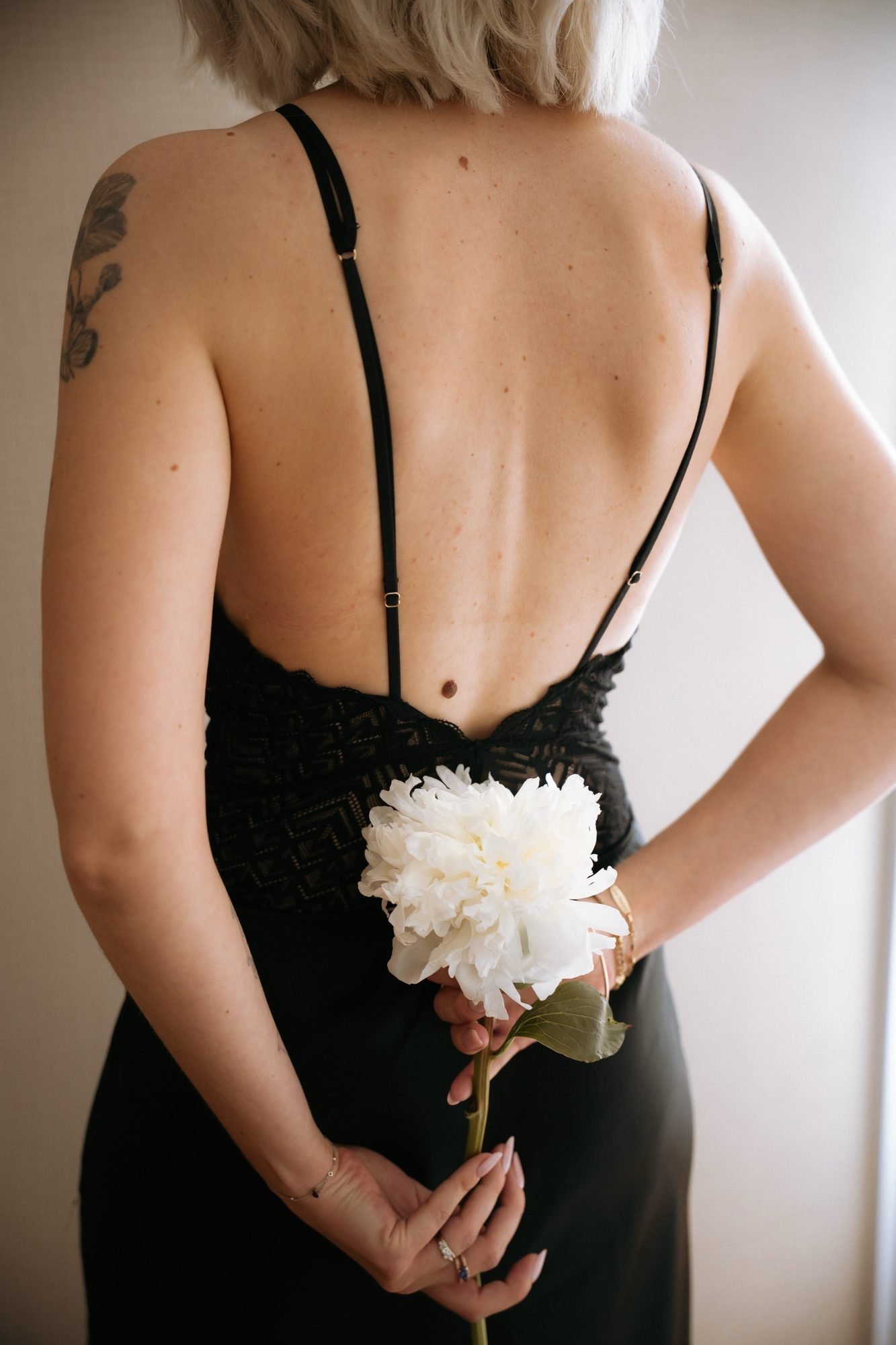 Une pivoine blanche tenue dans le dos, dentelle noire