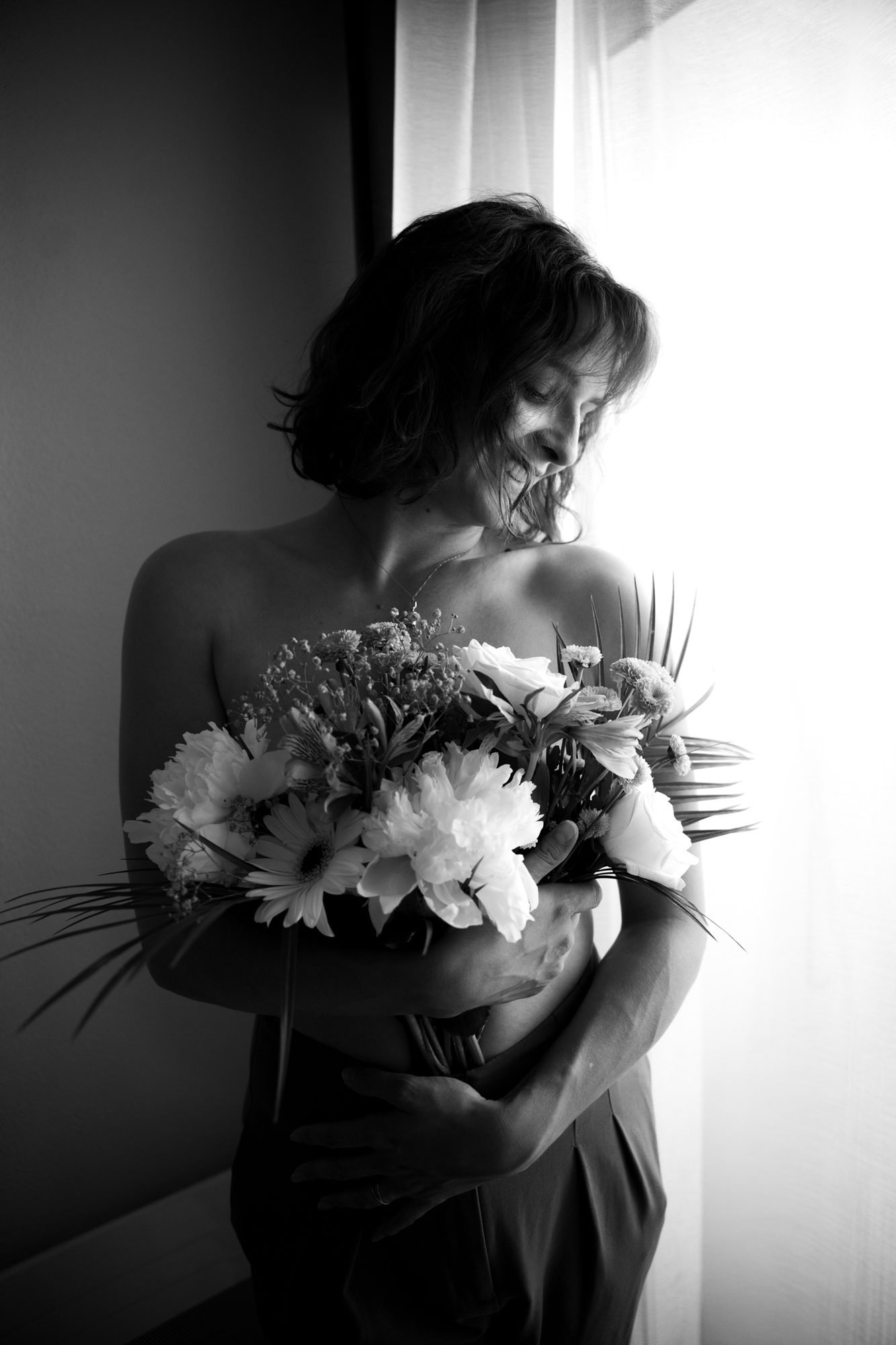 Dos dénudé, bouquet blanc contre la lumière