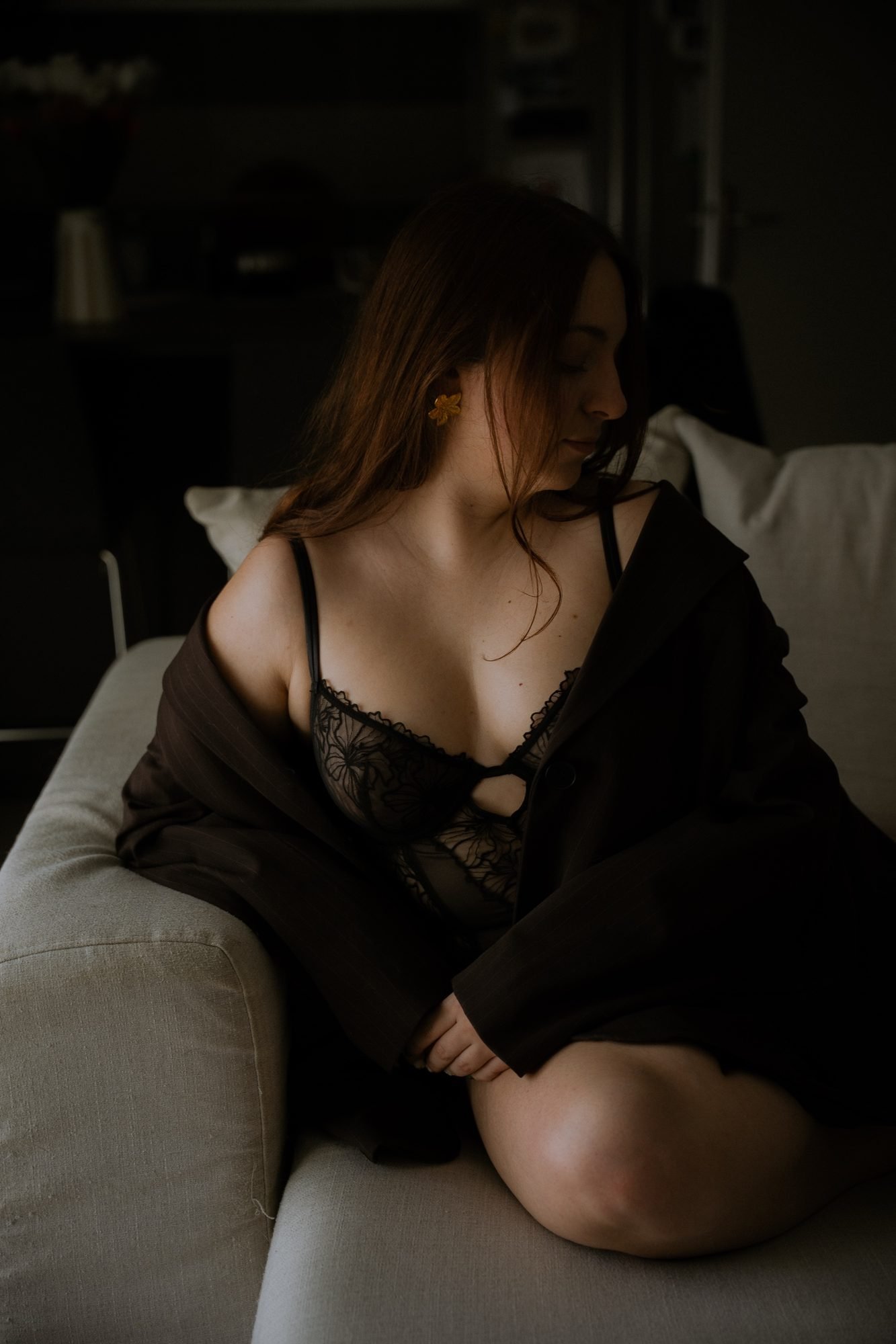 Portrait sur le canapé, lingerie de dentelle noire sous un blazer