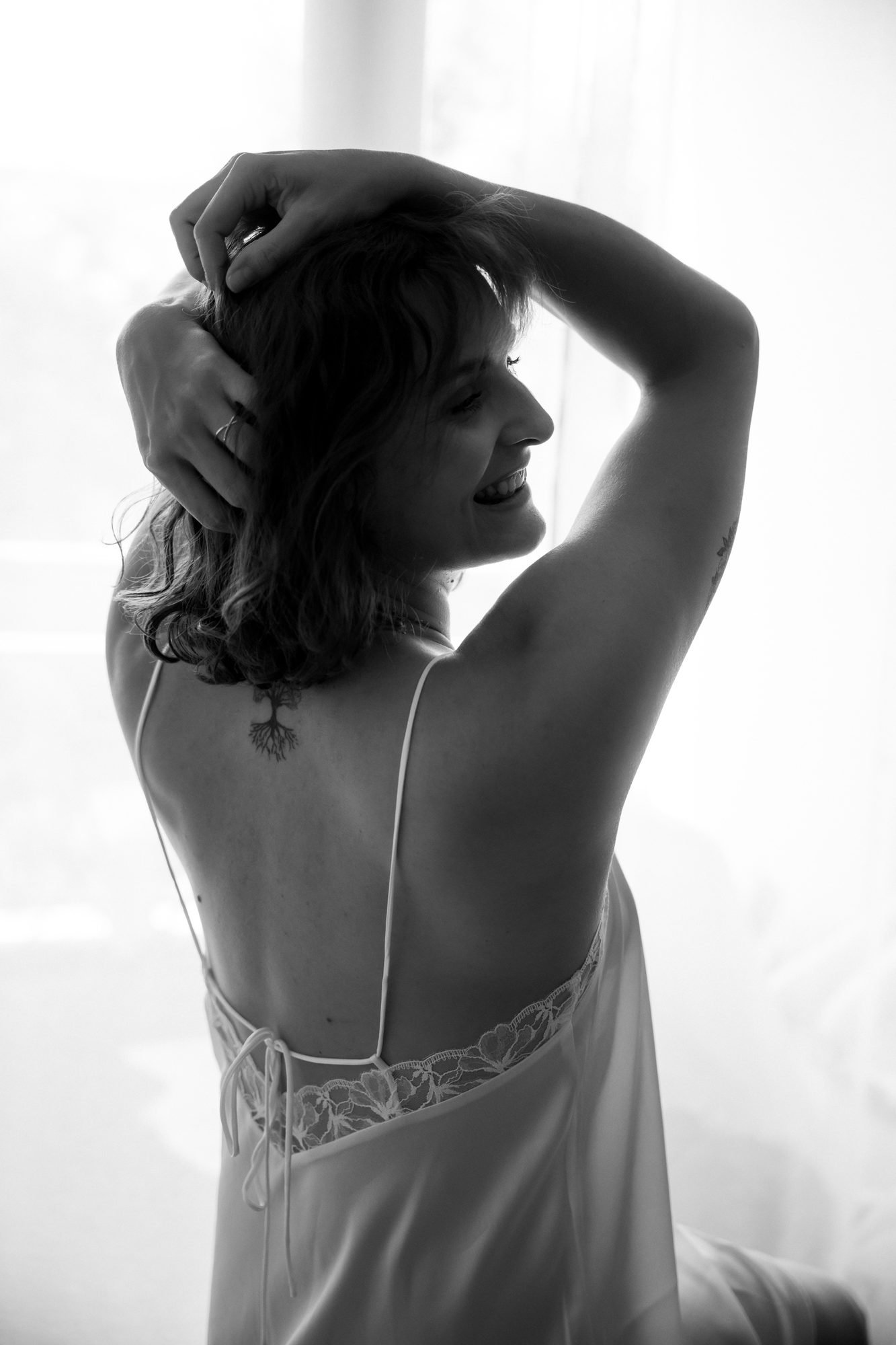 Dos dévoilé en noir et blanc, la main dans les cheveux