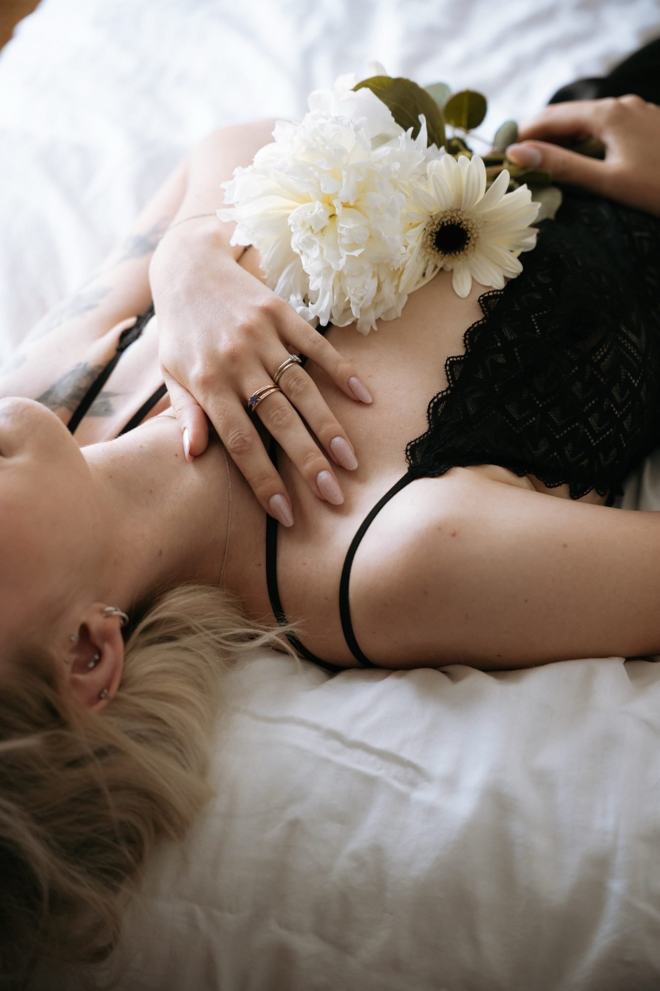 Gros plan sur la clavicule, fleurs blanches et dentelle noire